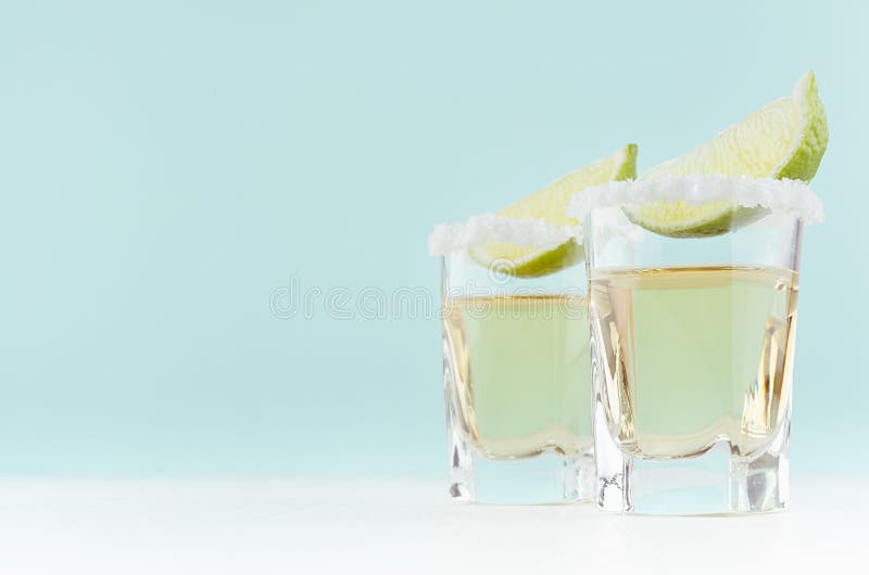 Cócteles frescos del alcohol del verano con tequila y la cal verde amarga en vaso de medida exquisito en verde blanco y en colore foto de archivo libre de regalías Cócteles frescos del alcohol del verano con tequila y la cal verde amarga en vaso de medida exquisito en verde blanco y en colore foto de archivo libre de regalías