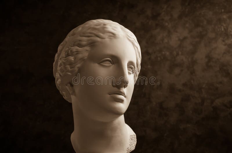 A cópia da gipsita do Vênus antigo da estátua dirige em um fundo textured escuro Cara da mulher da escultura do emplastro imagem de stock royalty free A cópia da gipsita do Vênus antigo da estátua dirige em um fundo textured escuro Cara da mulher da escultura do emplastro imagem de stock royalty free