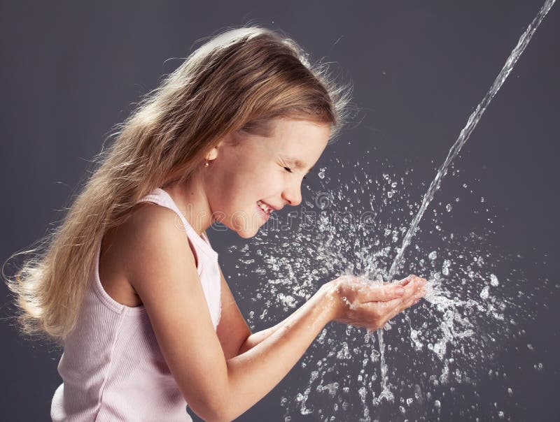 Stream of clean water pouring into children's hands. Child play with water. Stream of clean water pouring into children's hands. Child play with water