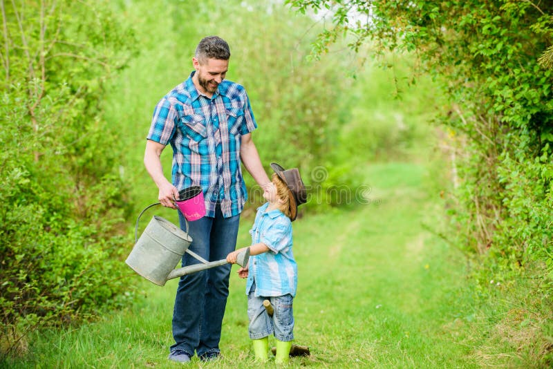 D?a de la Tierra feliz ?rbol de familia nursering Granja de Eco peque?o padre de la ayuda del ni?o del muchacho en el cultivo E foto de archivo libre de regalías D?a de la Tierra feliz ?rbol de familia nursering Granja de Eco peque?o padre de la ayuda del ni?o del muchacho en el cultivo E foto de archivo libre de regalías