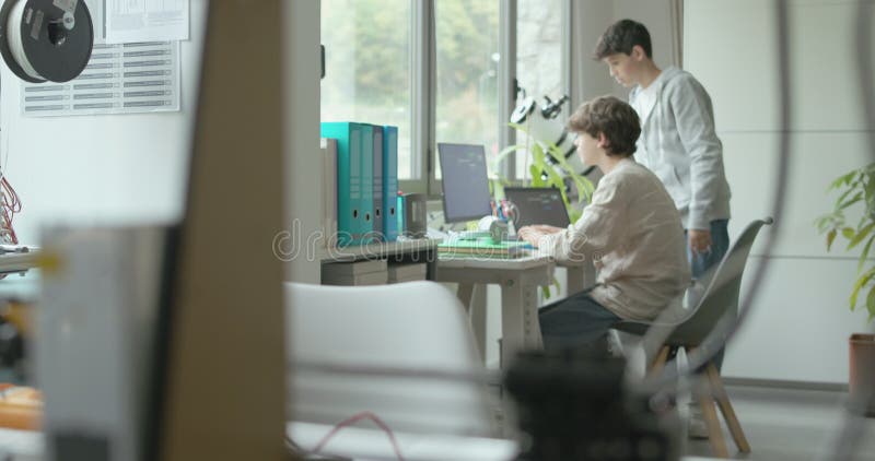 3D printer printing a prototype and engineering students stock footage
