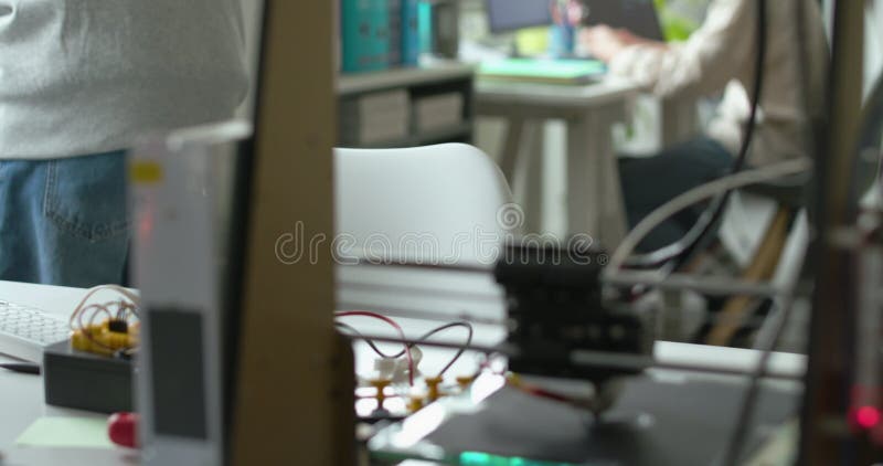 3D printer printing a prototype and engineering students stock video footage