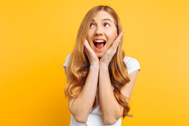 D'une jeune fille enthousiaste criant avec joie au-dessus de fond jaune images stock D'une jeune fille enthousiaste criant avec joie au-dessus de fond jaune images stock
