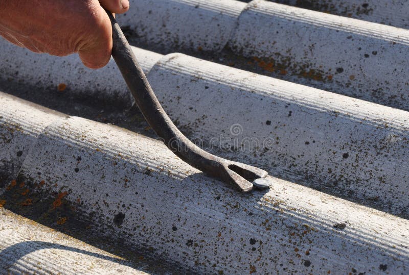 Close up on Roof worker repair dangerous asbestos old roof tiles. Close up on Roof worker repair dangerous asbestos old roof tiles.