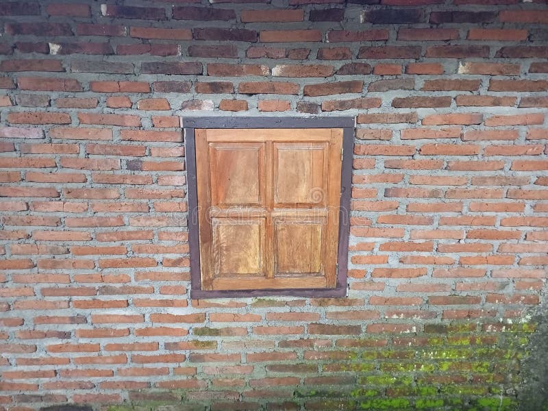 Dachziegelwand mit rustikalem Holzfenster lizenzfreie stockbilder