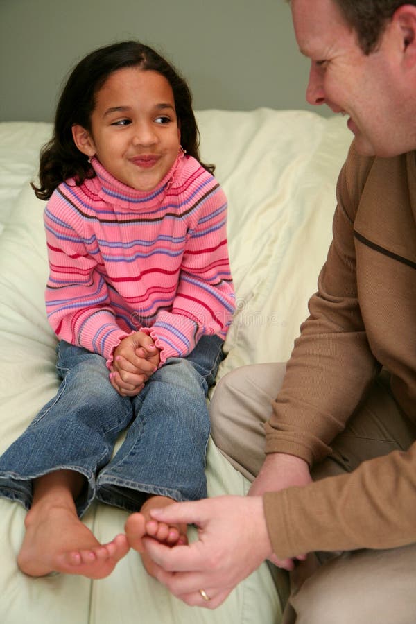 Dad tickles his daughter before she goes to bed. Dad tickles his daughter before she goes to bed