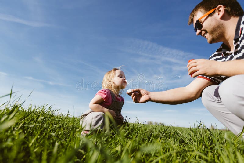 Dad and daughter blow bubbles. 