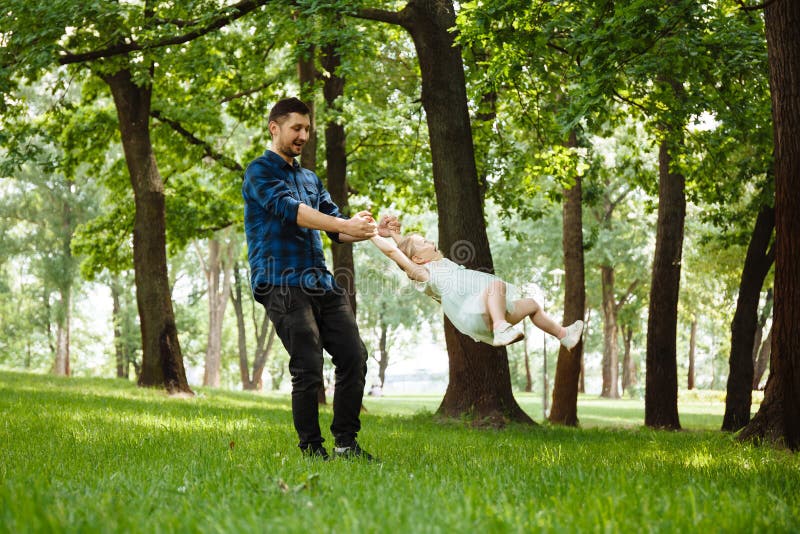 Dad and daughter have fun in park, girl flies with her father in his arms. Happy childhood stock photos Dad and daughter have fun in park, girl flies with her father in his arms. Happy childhood stock photos