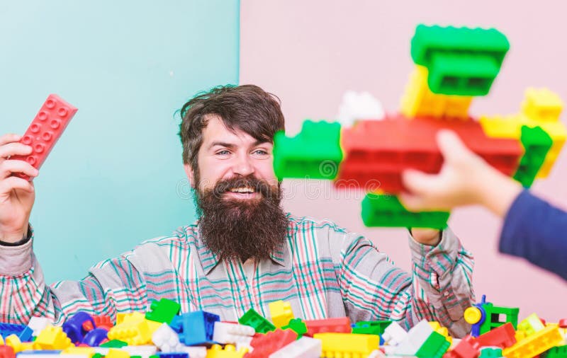 Dad and kid build plastic blocks. Child care and upbringing. Father son game. Father son create constructions. Father stock photos Dad and kid build plastic blocks. Child care and upbringing. Father son game. Father son create constructions. Father stock photos