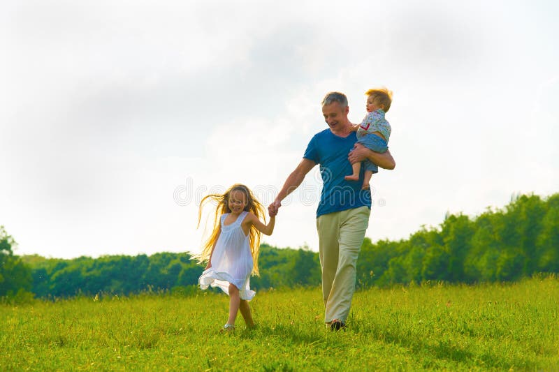 Otec s deťmi, prechádzky na trávniku.