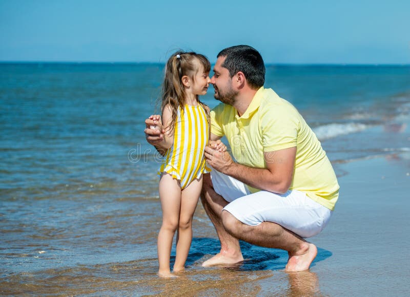 Dad and little girl play, run on the beach and fool around on the sea coast. Family vacation at sea with a child stock photography Dad and little girl play, run on the beach and fool around on the sea coast. Family vacation at sea with a child stock photography