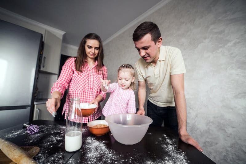 Dad, mom and daughter together in the kitchen. 