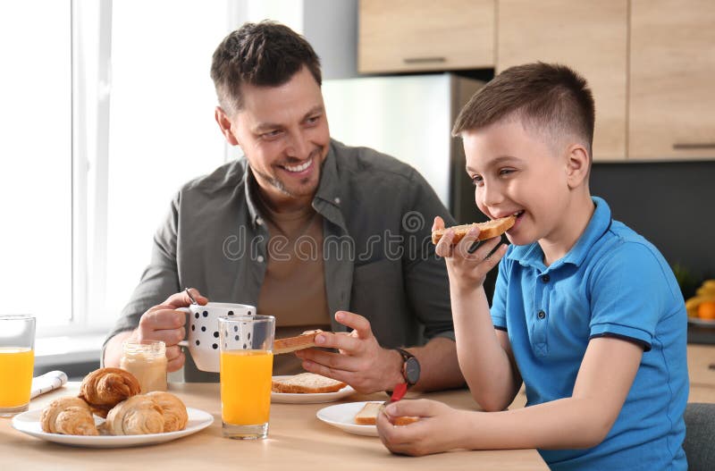 Dad and son having breakfast in kitchen royalty free stock photography Dad and son having breakfast in kitchen royalty free stock photography