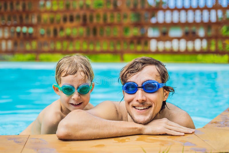 Dad And Son In Swimming Goggles Have Fun In The Pool Stock Image
