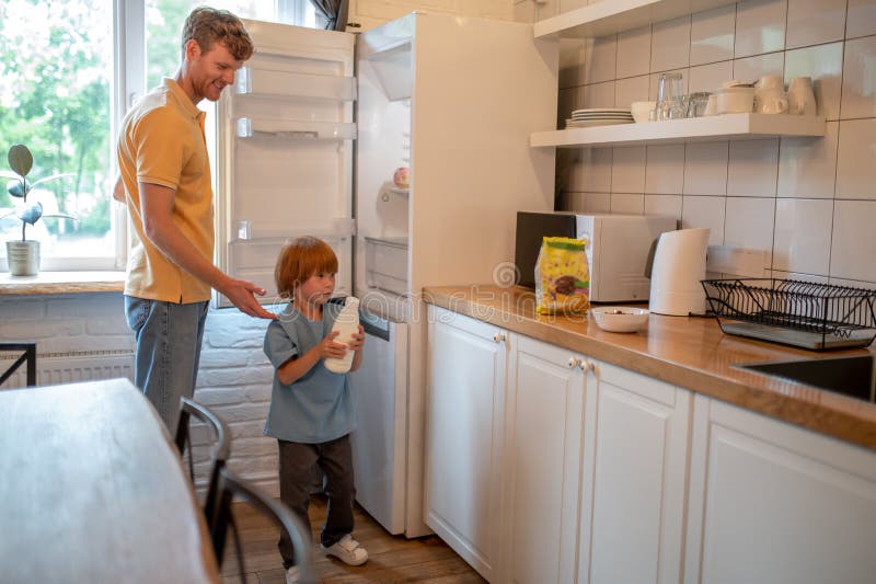 Dad and son in thre kitchen getting ready for breakfast stock photography