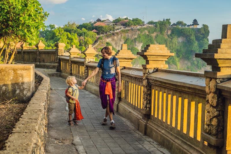 Dad and son travelers in Pura Luhur Uluwatu temple, Bali, Indonesia. Amazing landscape - cliff with blue sky and sea. Traveling wi stock photo Dad and son travelers in Pura Luhur Uluwatu temple, Bali, Indonesia. Amazing landscape - cliff with blue sky and sea. Traveling wi stock photo