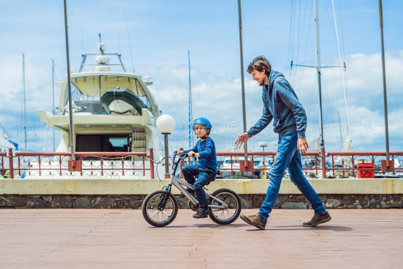 Dad Teaches Son To Ride a Bike in the Park Stoc