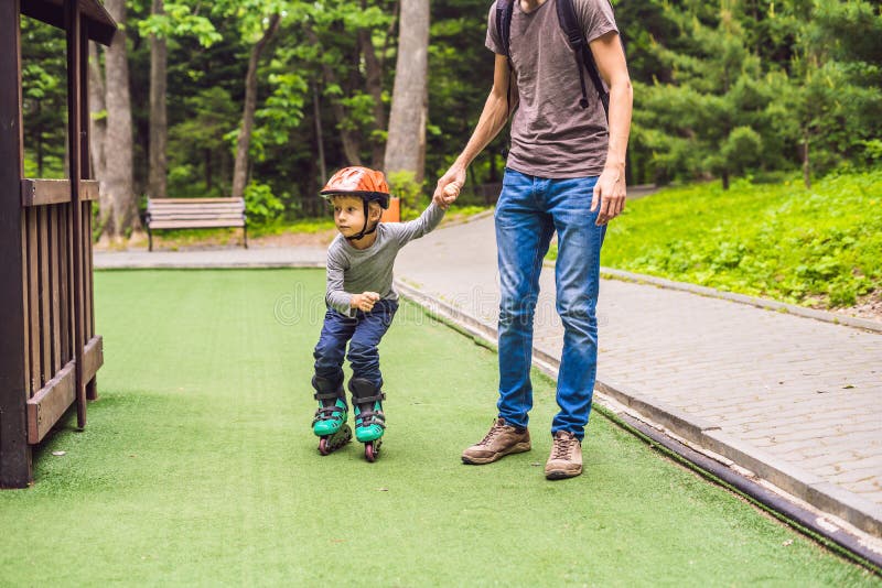 Dad Teaches Son To Rollerblade in the Park Stoc