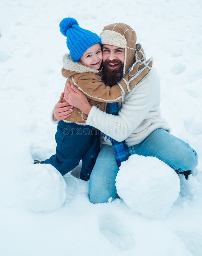 Daddy and boy smiling and hugging. Cute son hugs his dad on winter holiday. Merry Christmas and Happy New Year royalty free stock photography Daddy and boy smiling and hugging. Cute son hugs his dad on winter holiday. Merry Christmas and Happy New Year royalty free stock photography