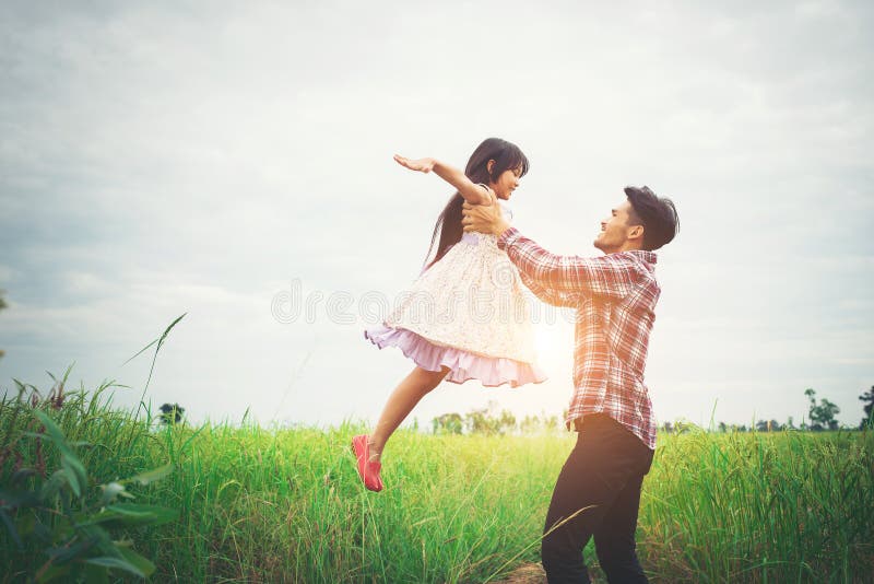 Daddy carrying his daughter with nature and sunlight, enjoyment