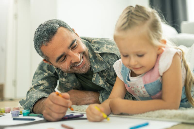 Daddy smiling while painting family tree with daughter