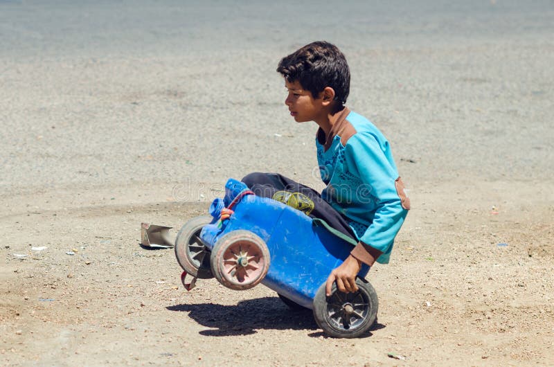 Dahab, Egypt May 11, 2019: little boy rides in a makeshift trolley from a plastic canister stock photography Dahab, Egypt May 11, 2019: little boy rides in a makeshift trolley from a plastic canister stock photography
