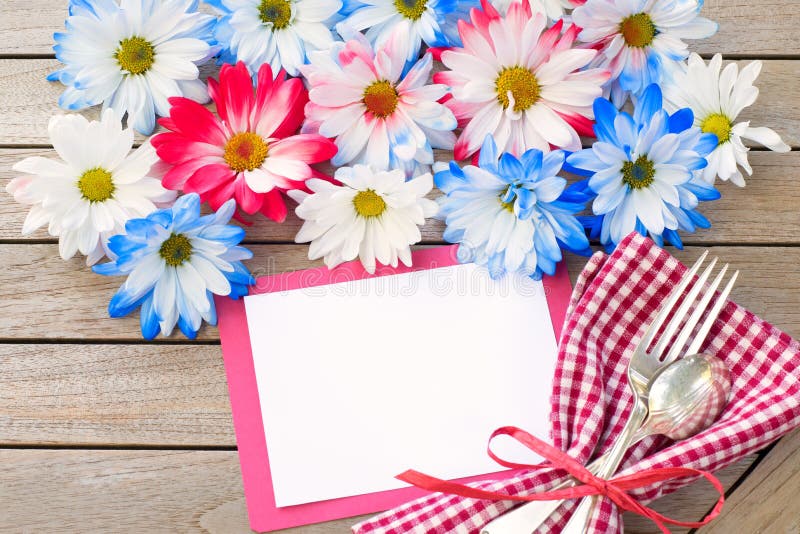 Daisy Flowers in Red White and Blue Colors with Party Invitation Card Laying on Rustic Board Table with room or space for your words, text, or copy. A flat layout and above view with horizontal crop. Daisy Flowers in Red White and Blue Colors with Party Invitation Card Laying on Rustic Board Table with room or space for your words, text, or copy. A flat layout and above view with horizontal crop