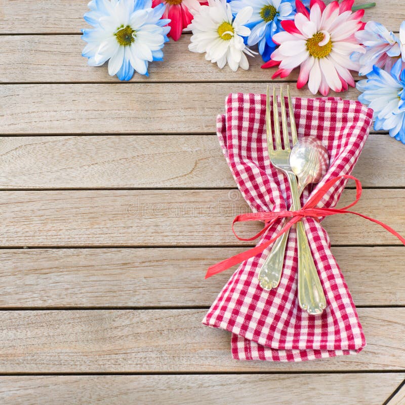 Daisy Flowers in Red White and Blue with Silverware and Napkin Laying on side of Rustic Board Table with room or space for your wo