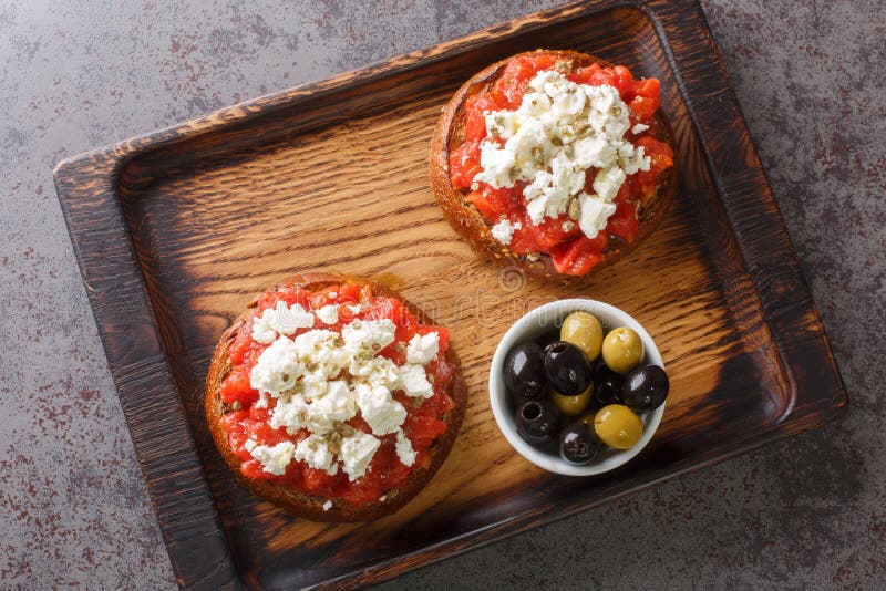 Dakos constă dintr-o felie de pâine cracată din orz și curățată cu roșii cojite zdrobite sau măcinate și feta feta sfărâmată cu or stock photo