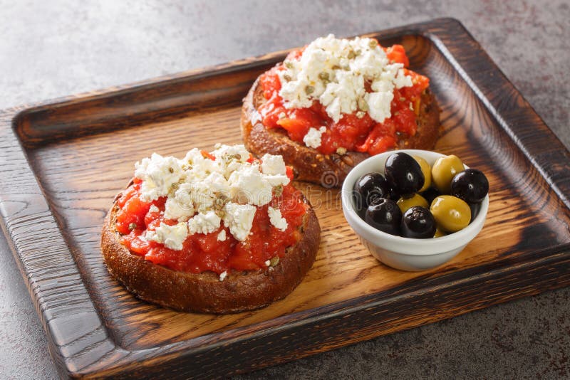 Dakos constă dintr-o felie de pâine cracată din orz și curățată cu roșii cojite zdrobite sau măcinate și feta feta sfărâmată cu or royalty free stock photography