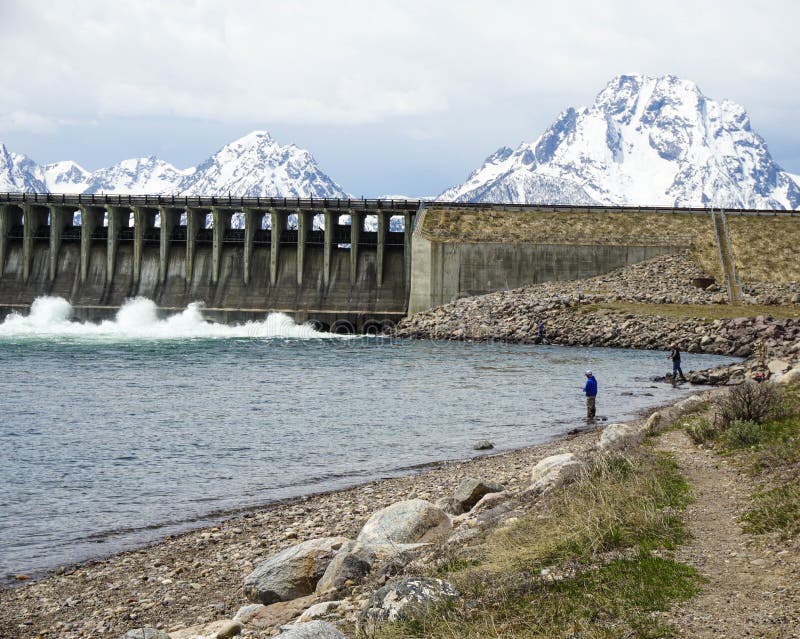 Dam by lake with snowy mountains at national park