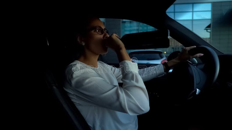 Dam som dricker vin och kör bilen som avlöser spänning, hemfallen person för alkohol arkivbild Dam som dricker vin och kör bilen som avlöser spänning, hemfallen person för alkohol arkivbild