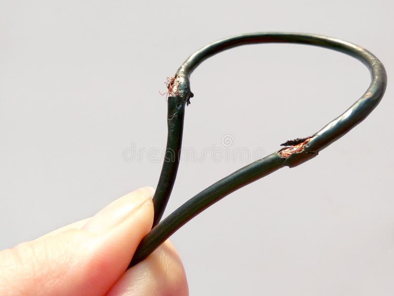 Damaged black electric cord on white background. Dangerous broken electrical cable stock image Damaged black electric cord on white background. Dangerous broken electrical cable stock image