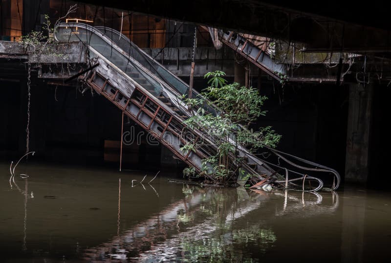 Damaged escalators and waterlogged in abandoned shopping mall building