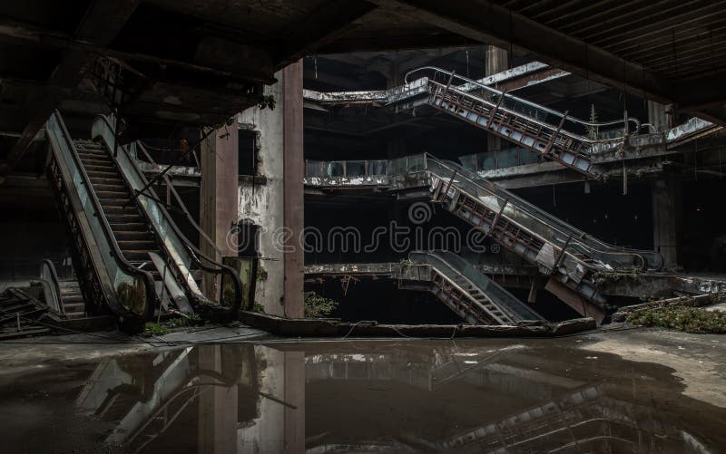 Damaged escalators and waterlogged in abandoned shopping mall building