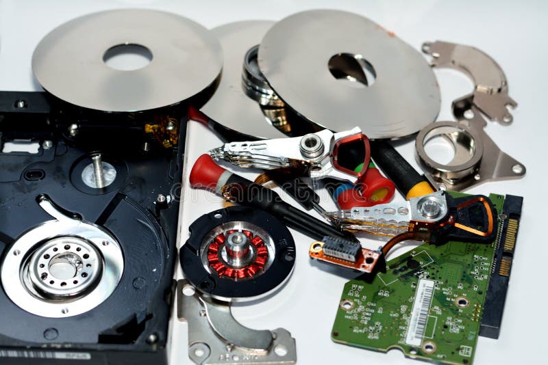 Damaged Hard disk drive components with disks, read write head, spindle motor, suspension, pivot, voice coil motor VCM, E-block stock photos