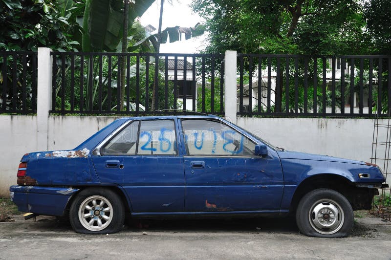 A blue damaged old car on roadside