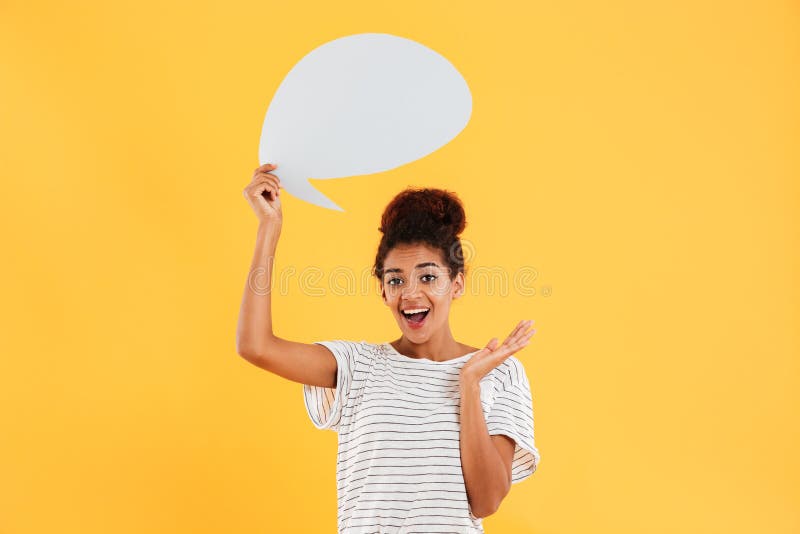 Dame assez africaine tenant la bulle vide de la parole tout en se tenant d'isolement photos stock Dame assez africaine tenant la bulle vide de la parole tout en se tenant d'isolement photos stock
