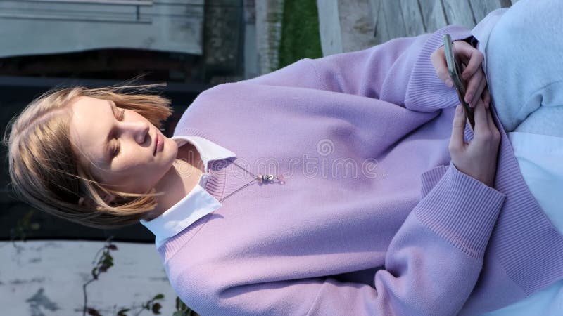 Dame blonde avec cheveux courts sur téléphone noir dans la rue clips vidéos