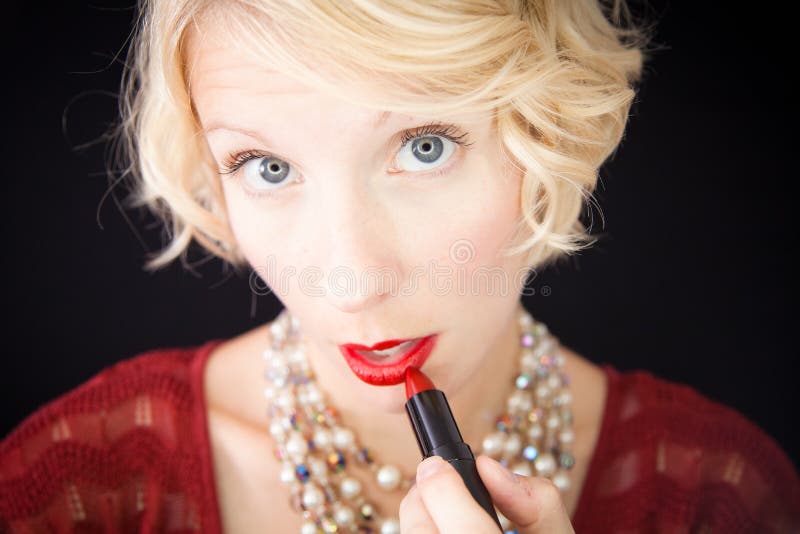 Dame, die Lippenstift setzt (wie vor einem Spiegel) lizenzfreie stockbilder Dame, die Lippenstift setzt (wie vor einem Spiegel) lizenzfreie stockbilder