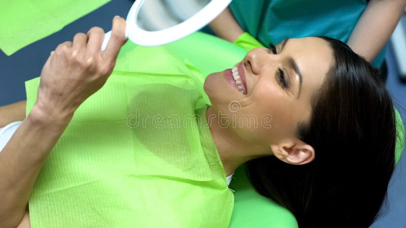 Dame gelukkig met resultaat van tandbehandeling, professionele hulp kosmetische tandheelkunde