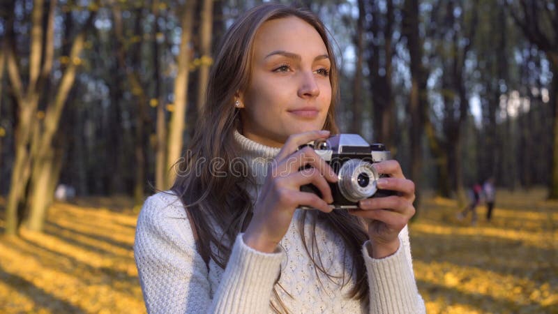 Dame het bewonderen de herfst door uitstekende cameralens en het proberen om ogenblik te vangen