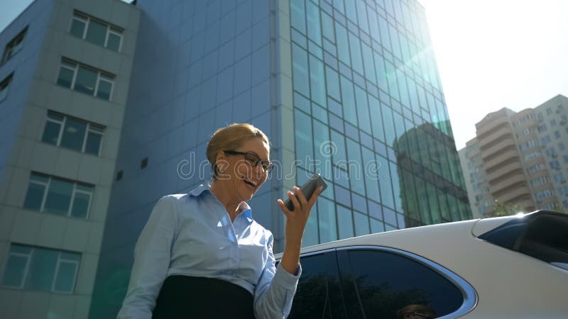 Dame heureuse se réjouissant la promotion en ligne ou le contrat réussi par le smartphone images stock Dame heureuse se réjouissant la promotion en ligne ou le contrat réussi par le smartphone images stock