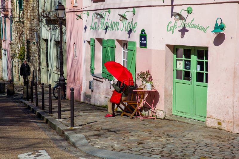 Dame met een rode paraplu bij het roze huisrestaurant in beroemde Montmartre royalty-vrije stock fotografie Dame met een rode paraplu bij het roze huisrestaurant in beroemde Montmartre royalty-vrije stock fotografie