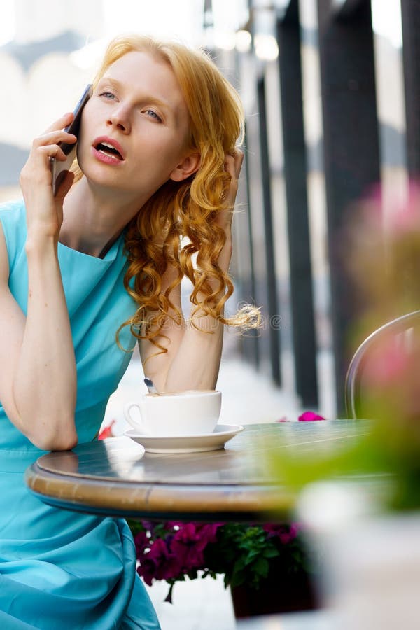 Dame mit dem gelockten blonden Haar sprechend am Telefon im Café lizenzfreies stockbild Dame mit dem gelockten blonden Haar sprechend am Telefon im Café lizenzfreies stockbild
