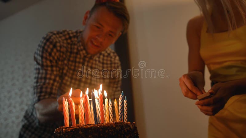 Dame sexy et bougies belles de lumières de type sur le gâteau d'anniversaire savoureux Prepearing pour la partie