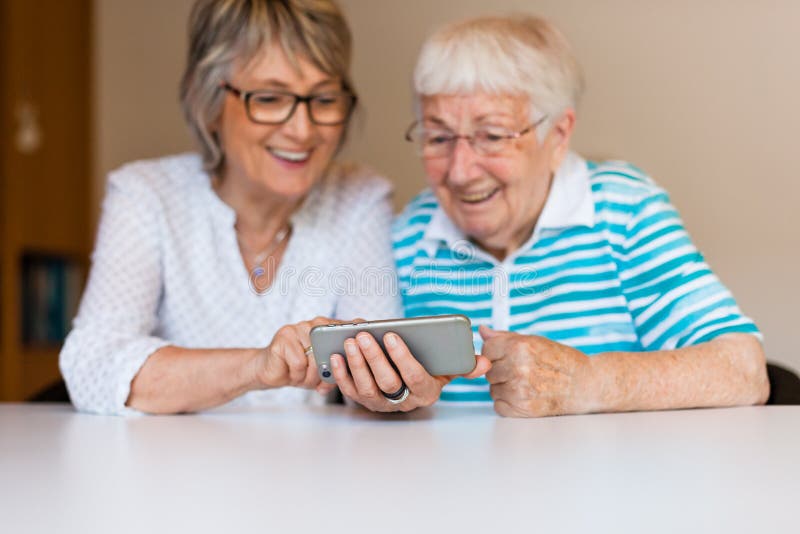 Dame âgée utilisant un smartphone avec sa mère images stock