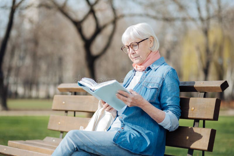 Dame âgée concentrée lisant un livre photographie stock libre de droits Dame âgée concentrée lisant un livre photographie stock libre de droits