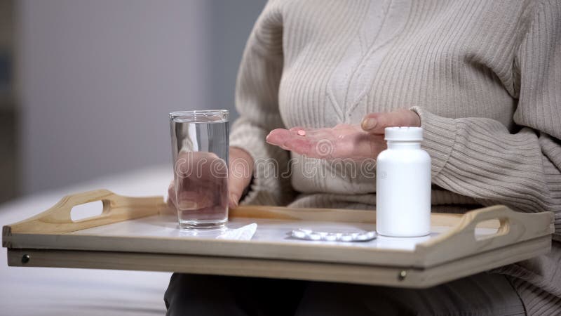 Dame âgée prenant des pilules au centre médical, souffrant du problème de santé, la maladie photographie stock libre de droits Dame âgée prenant des pilules au centre médical, souffrant du problème de santé, la maladie photographie stock libre de droits