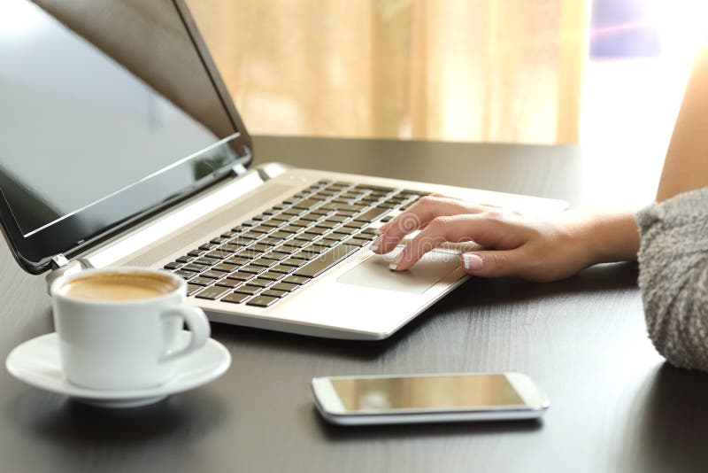 Damenhand, die zu Hause einen Laptop grast stockfotos Damenhand, die zu Hause einen Laptop grast stockfotos